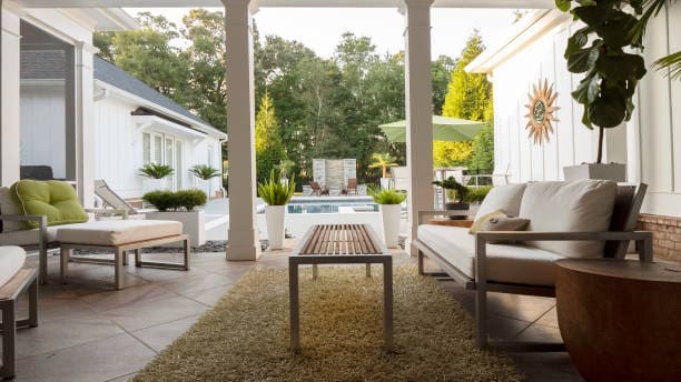 Cozy outdoor patio with comfortable seating and a green garden view.